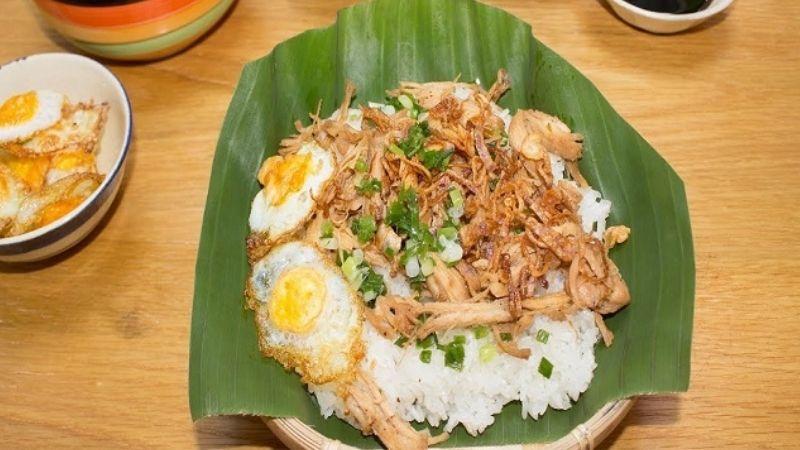 Xôi gà: sticky rice with shredded chicken and crispy fried shallots in a takeaway box