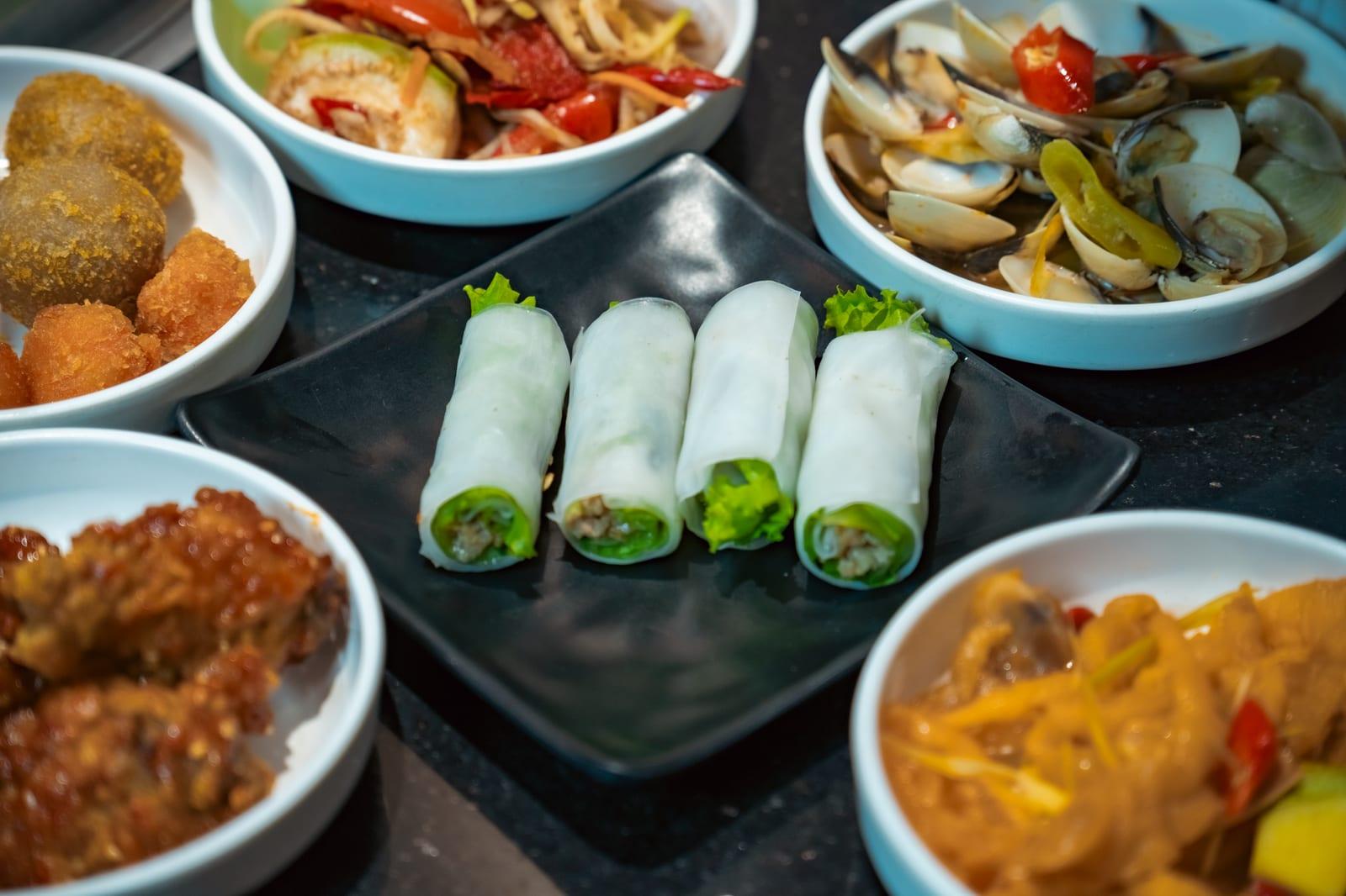 A nhậu spread of seafood and snacks (mồi) shared around a table with cold beer.